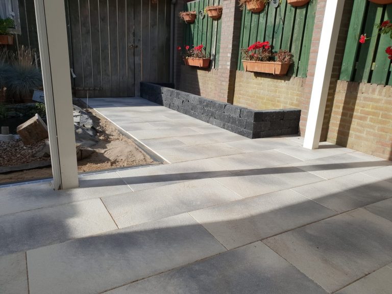 Grijs gemeleerde sierbestrating met plantenbak van splitrocks
