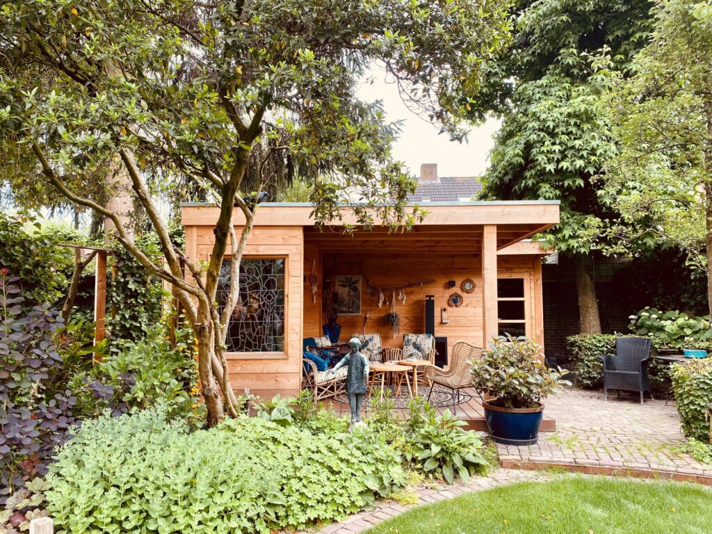 Overkapping van Douglas hout met loungeset in een groene tuin